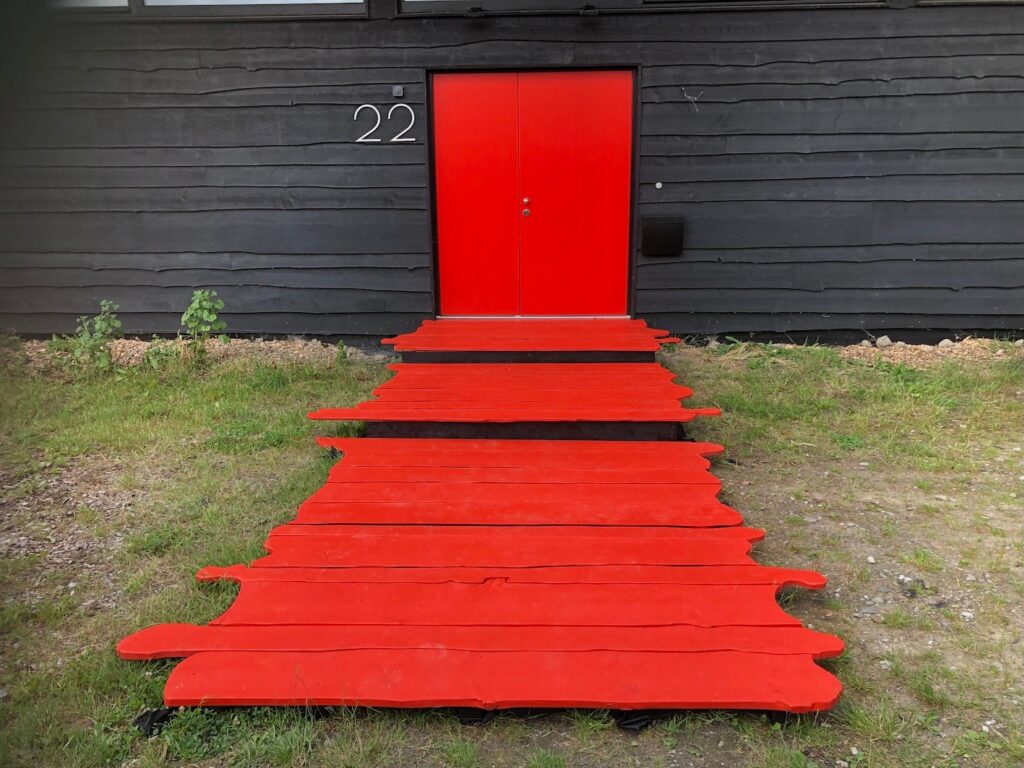 Prive eventlocatie met een rode deur en een rode loper