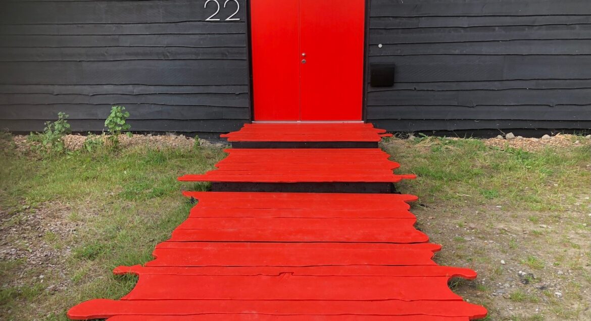 Prive eventlocatie met een rode deur en een rode loper