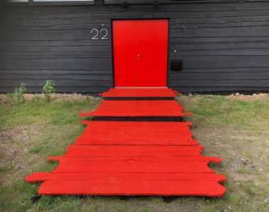 Prive eventlocatie met een rode deur en een rode loper