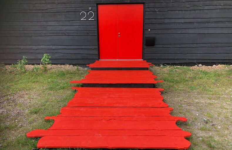 Prive eventlocatie met een rode deur en een rode loper